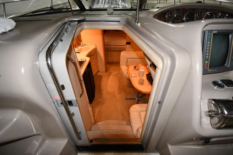 Slide: The Image of Interior view of 2000 Sea Ray 370 Express Cruiser, featuring cozy seating and kitchenette. - 22