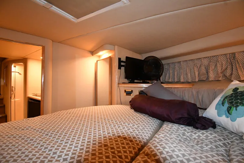 Slide: The Image of Interior cabin of 2000 Sea Ray 370 Express Cruiser with cozy bedding and TV. - 27
