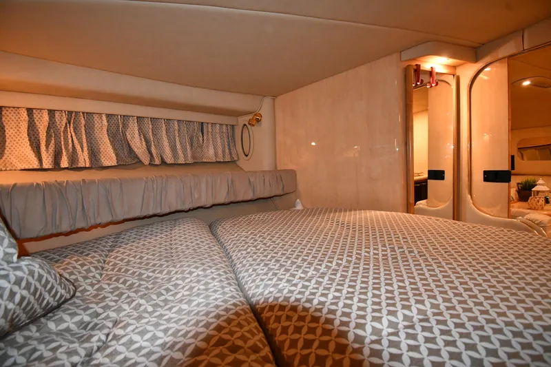 Slide: The Image of Interior cabin of 2000 Sea Ray 370 Express Cruiser with patterned bedding and cozy lighting. - 28