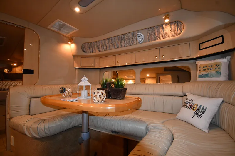 Slide: The Image of 2000 Sea Ray 370 Express Cruiser interior with beige seating and wooden table. - 29