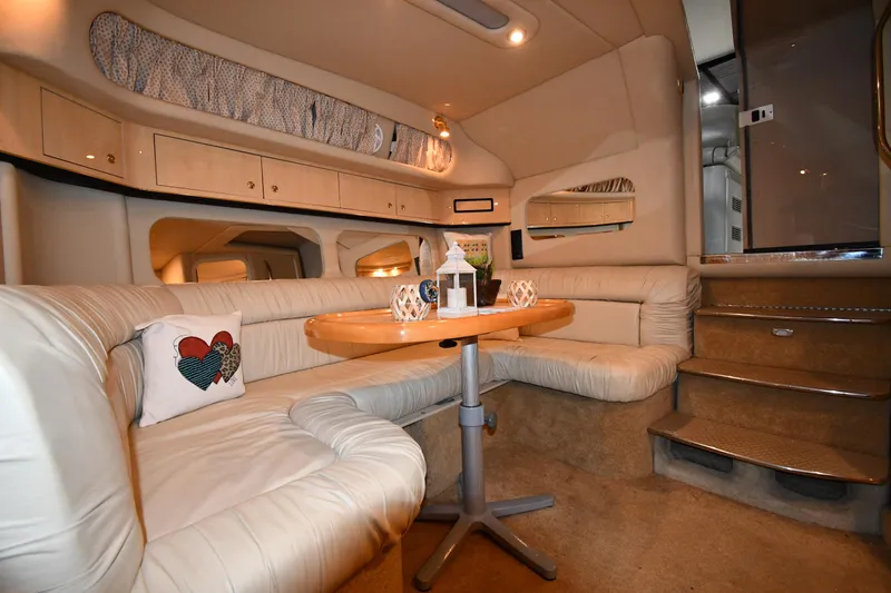 Slide: The Image of Interior of 2000 Sea Ray 370 Express Cruiser with plush seating and wooden table. - 35