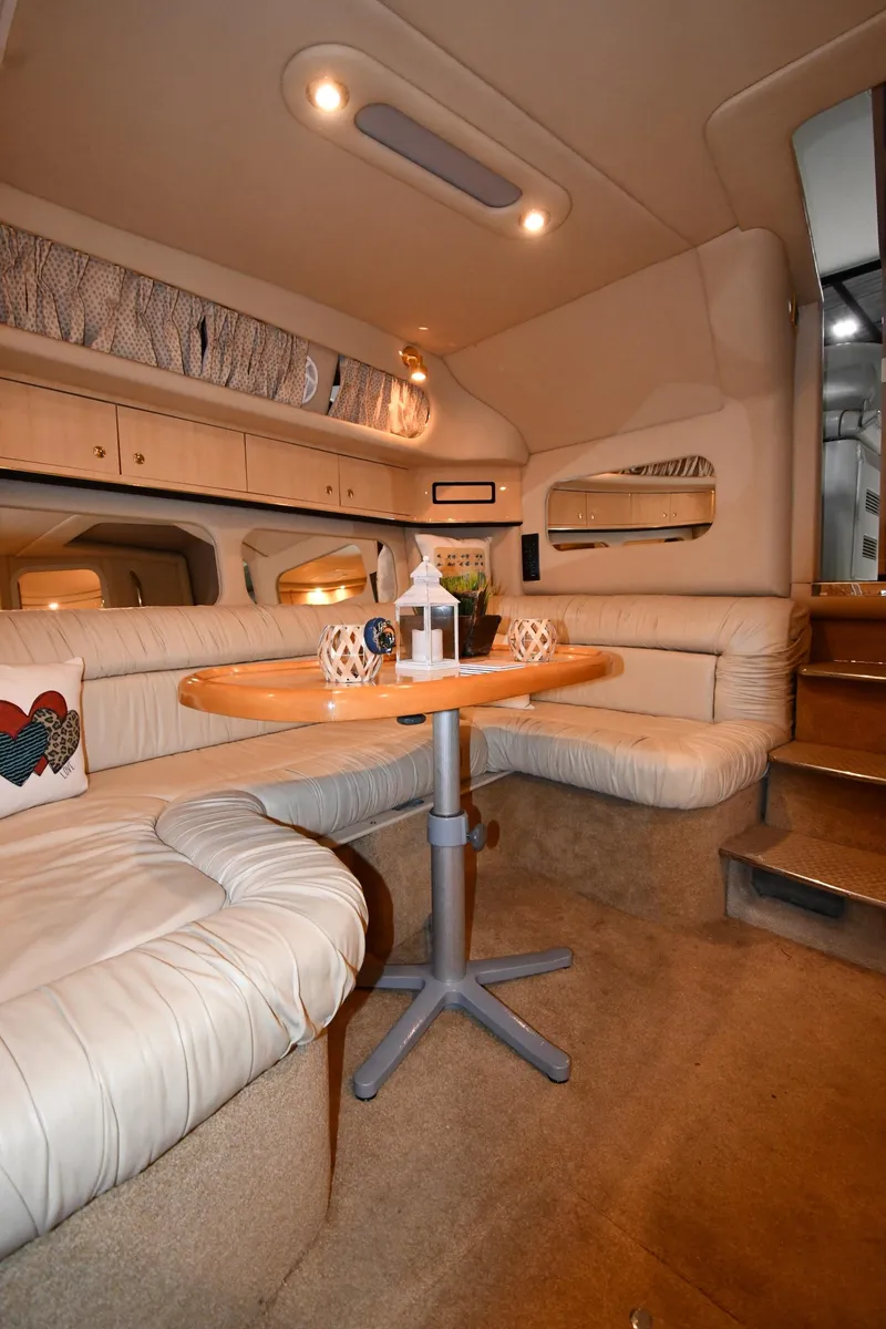 Slide: The Image of Interior of 2000 Sea Ray 370 Express Cruiser with cozy seating and wooden table. - 36