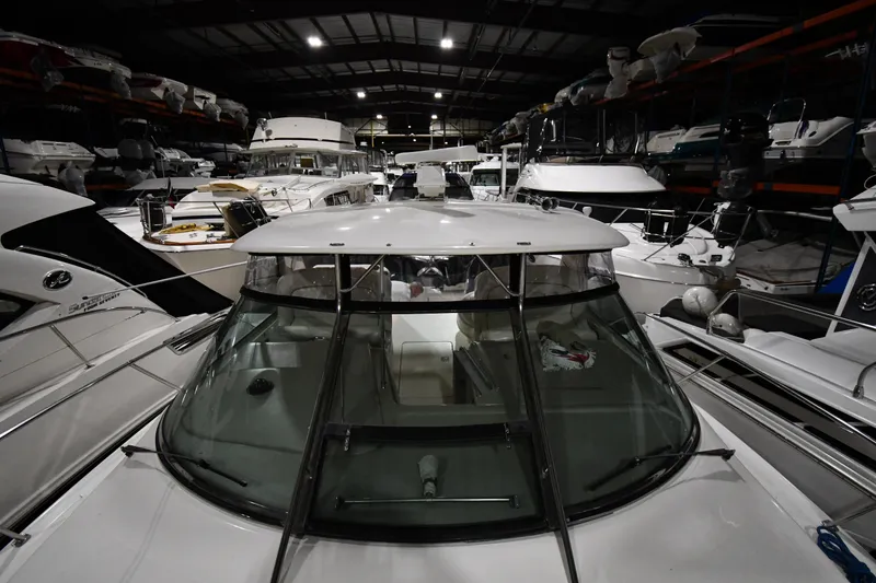 Slide: The Image of 2000 Sea Ray 370 Express Cruiser in indoor storage, surrounded by other boats. - 4