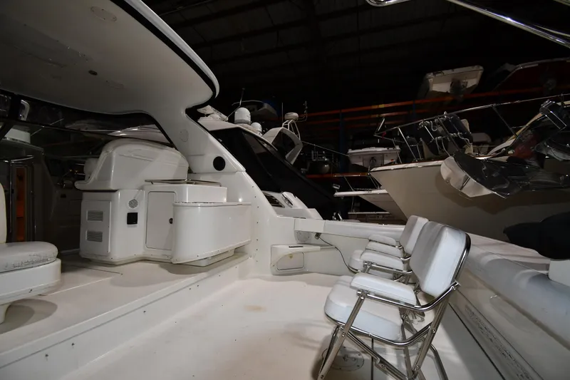 Slide: The Image of 2000 Sea Ray 370 Express Cruiser interior with seating and helm in a storage facility. - 5