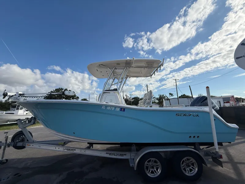 Slide: The Image of 2021 Sea Fox 228 Commander boat on trailer under a partly cloudy sky. - 1