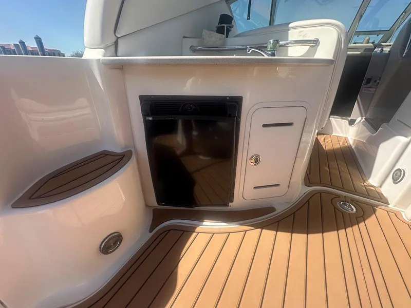 Slide: The Image of 2007 Sea Ray 320 Sundancer interior with wood flooring and compact kitchenette. - 10
