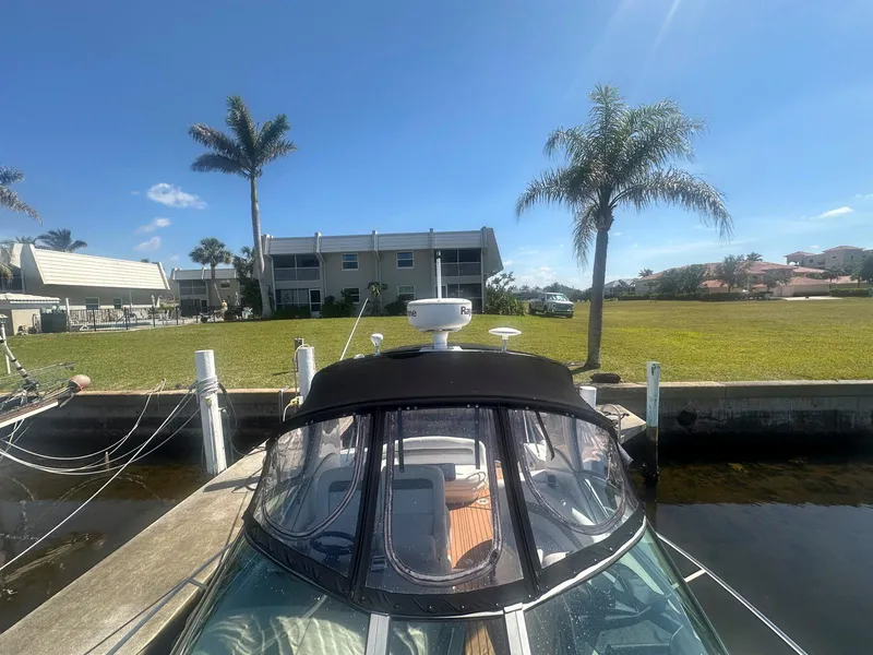 Slide: The Image of 2007 Sea Ray 320 Sundancer docked near waterfront homes and palm trees. - 11