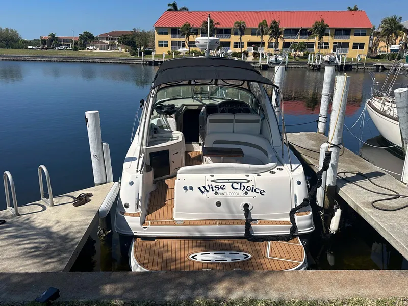 Slide: The Image of 2007 Sea Ray 320 Sundancer docked at marina, rear view with "Wise Choice" name. - 12