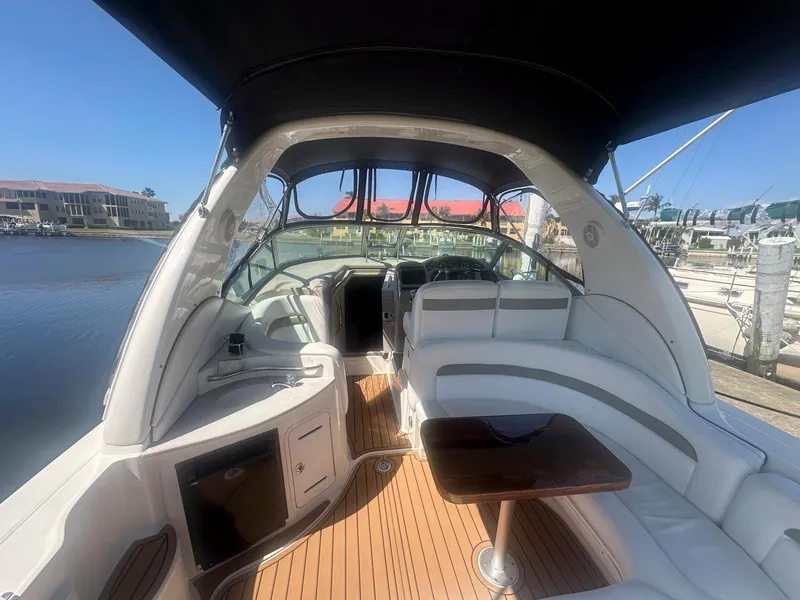 Slide: The Image of 2007 Sea Ray 320 Sundancer boat interior with white seating and wooden flooring. - 2
