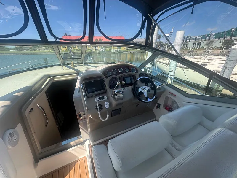 Slide: The Image of 2007 Sea Ray 320 Sundancer cockpit with steering wheel and control panel, docked at marina. - 4