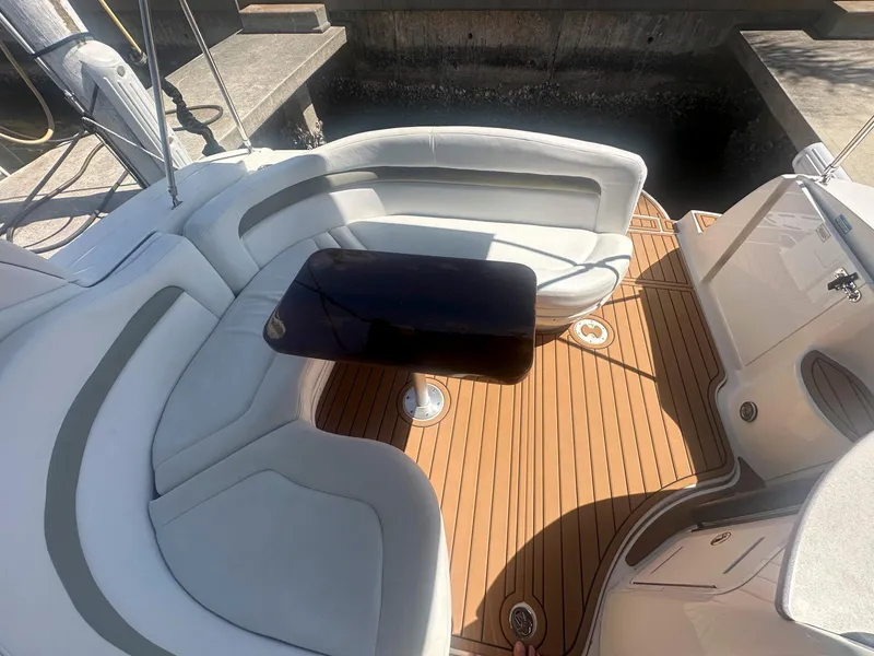 Slide: The Image of 2007 Sea Ray 320 Sundancer boat interior with white seating and wooden deck. - 6