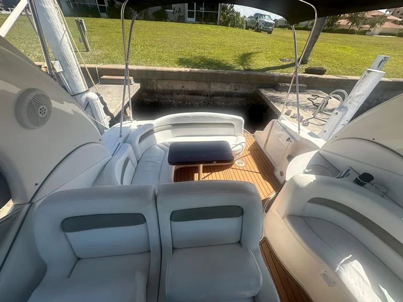 Slide: The Image of 2007 Sea Ray 320 Sundancer boat interior with white seating and wooden deck. - 8