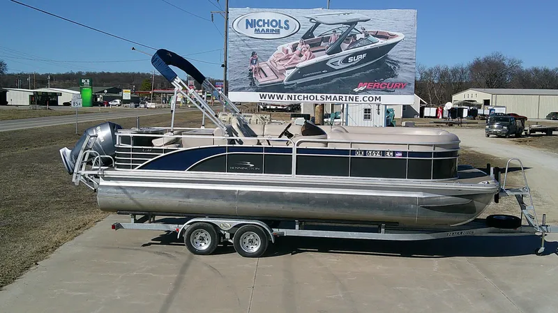 Slide: The Image of 2015 Bennington G 22 pontoon boat on trailer at Nichols Marine dealership. - 1