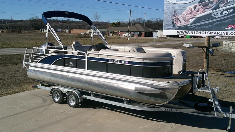 Slide: The Image of 2015 Bennington G 22 pontoon boat on trailer, parked outdoors under clear sky. - 2
