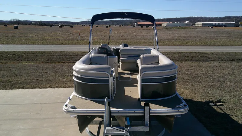 Slide: The Image of 2015 Bennington G 22 pontoon boat on trailer, parked in rural setting. - 3