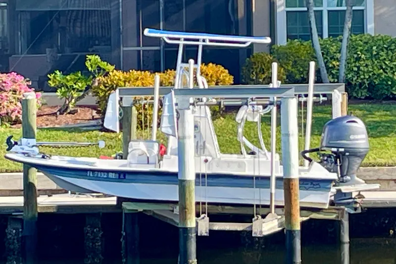 Slide: The Image of 2016 Shallow Sport 18 Sport boat docked on a lift by the waterfront. - 1