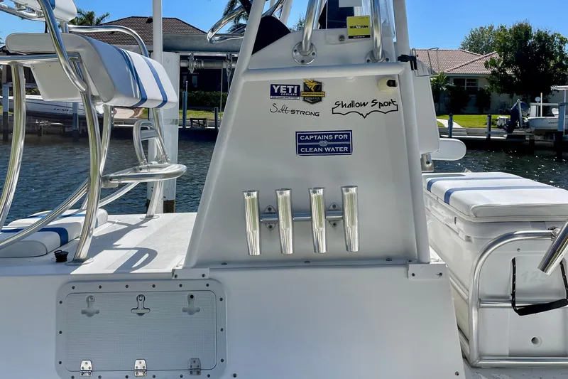 Slide: The Image of 2016 Shallow Sport 18 Sport boat interior with fishing rod holders and brand stickers. - 13