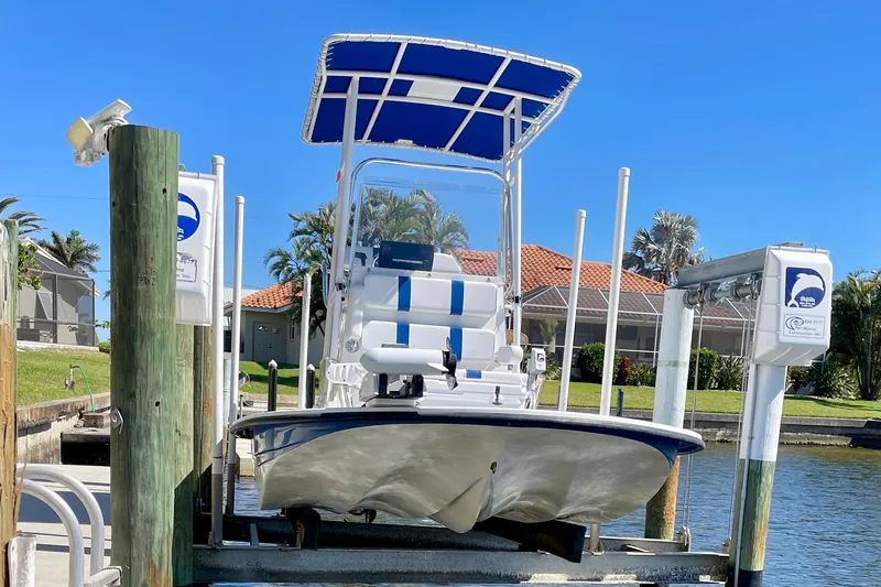Slide: The Image of 2016 Shallow Sport 18 Sport boat docked on a lift by the water. - 2