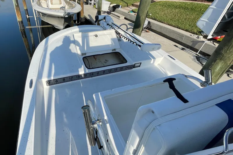 Slide: The Image of 2016 Shallow Sport 18 Sport boat docked, featuring spacious deck and seating. - 5