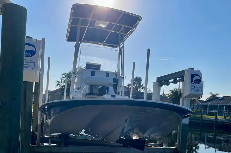 Slide: The Image of 2016 Shallow Sport 18 Sport boat on lift, sunny day, waterfront setting. - 8