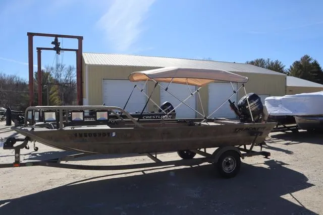 Slide: The Image of 2016 Tracker Grizzly 1860 MVX boat on trailer, parked outdoors. - 16