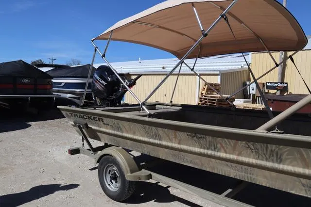Slide: The Image of 2016 Tracker Grizzly 1860 MVX boat with canopy on trailer, outdoor setting. - 18