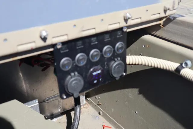 Slide: The Image of Control panel of a 2016 Tracker Grizzly 1860 MVX boat, featuring multiple switches and dials. - 6