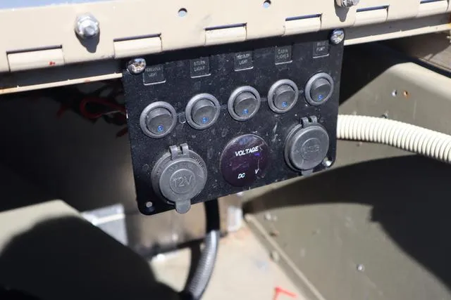 Slide: The Image of Control panel of a 2016 Tracker Grizzly 1860 MVX boat with voltage and power outlets. - 7