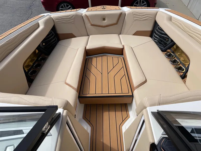 Slide: The Image of 2025 Nautique Super Air Nautique G25 boat interior with beige seating and wood accents. - 11