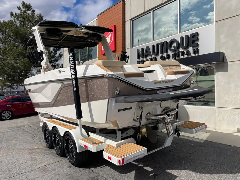 Slide: The Image of 2025 Nautique Super Air Nautique G25 boat on trailer outside dealership. - 3