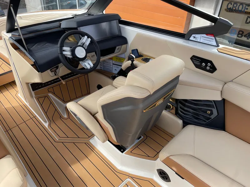 Slide: The Image of 2025 Nautique Super Air Nautique G25 interior with beige seating and modern dashboard. - 6