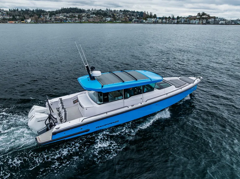 Slide: The Image of 2021 Axopar 37xc Wetbar cruising on open water, showcasing sleek design and vibrant blue accents. - 18