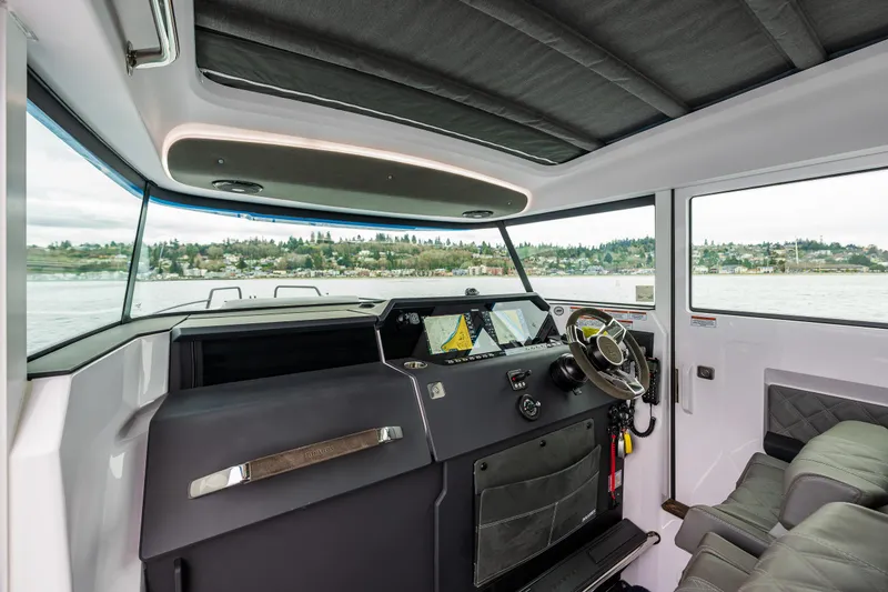 Slide: The Image of 2021 Axopar 37xc Wetbar interior with modern helm and panoramic windows. - 24