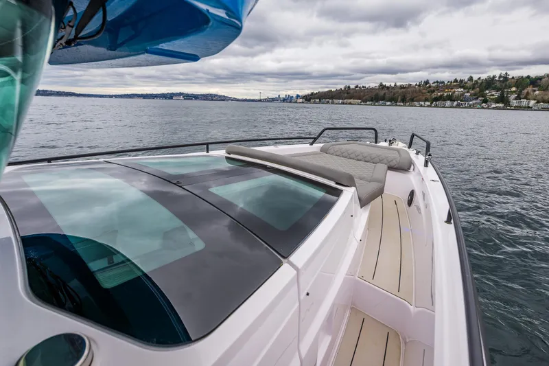 Slide: The Image of 2021 Axopar 37xc Wetbar boat cruising on a scenic lake under cloudy skies. - 30