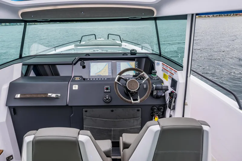 Slide: The Image of 2021 Axopar 37xc Wetbar boat cockpit with steering wheel and navigation screens. - 38