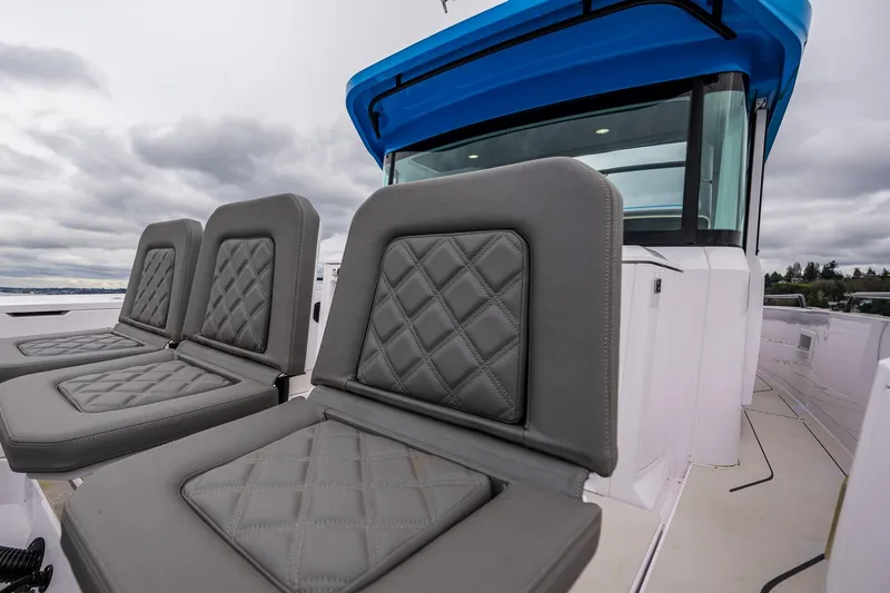 Slide: The Image of 2021 Axopar 37xc Wetbar boat with gray quilted seats and blue canopy. - 42