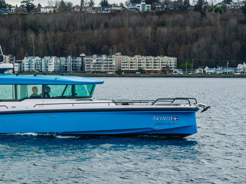 Slide: The Image of 2021 Axopar 37xc Wetbar boat cruising near waterfront buildings. - 7