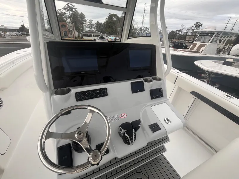 Slide: The Image of 2025 Tidewater 302 CC Adventure boat cockpit with dual screens and steering wheel. - 11