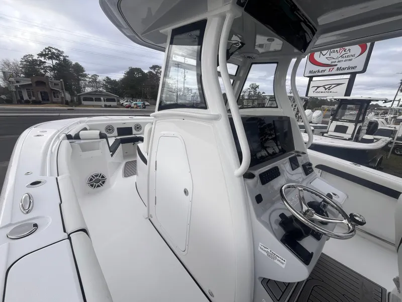 Slide: The Image of 2025 Tidewater 302 CC Adventure boat interior with modern helm and seating. - 12