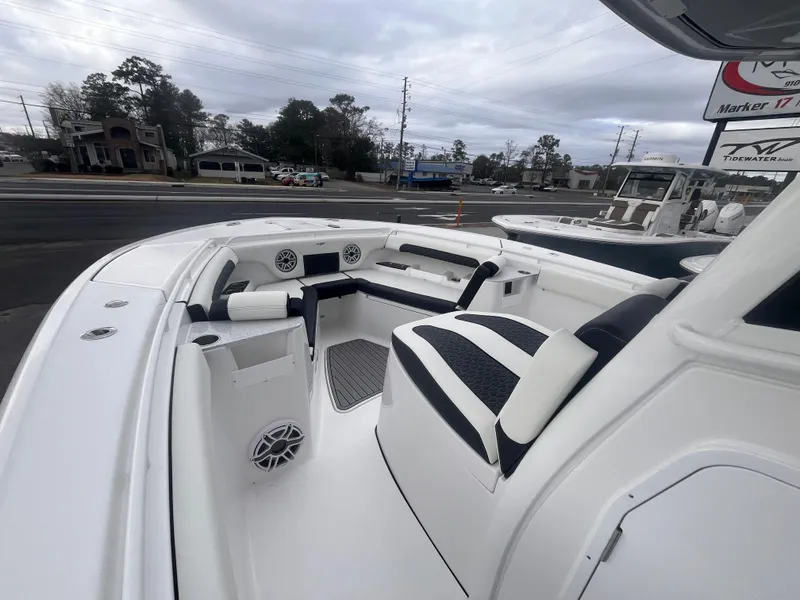 Slide: The Image of 2025 Tidewater 302 CC Adventure boat interior with seating and speakers, docked outdoors. - 13