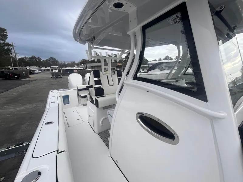 Slide: The Image of 2025 Tidewater 302 CC Adventure boat, white exterior, docked, side view. - 16