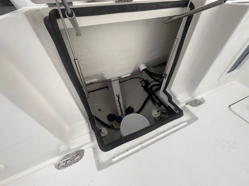 Slide: The Image of 2025 Tidewater 302 CC Adventure boat hatch interior with visible wiring and components. - 19