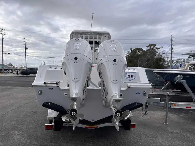 Slide: The Image of 2025 Tidewater 302 CC Adventure boat with dual outboard engines, parked on a trailer. - 4