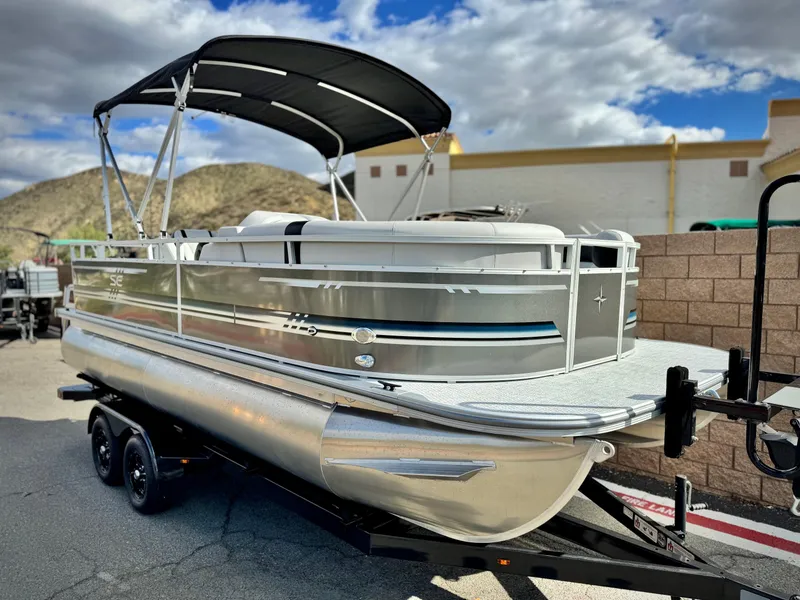 Slide: The Image of 2025 Berkshire 20 CRSE pontoon boat on trailer, parked outdoors under cloudy sky. - 1