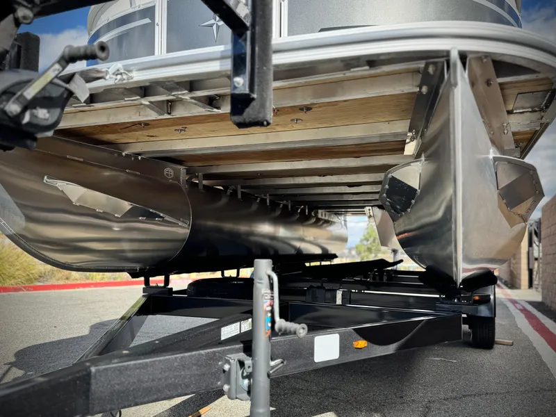 Slide: The Image of 2025 Berkshire 20 CRSE pontoon boat on trailer, showcasing undercarriage and pontoons. - 4