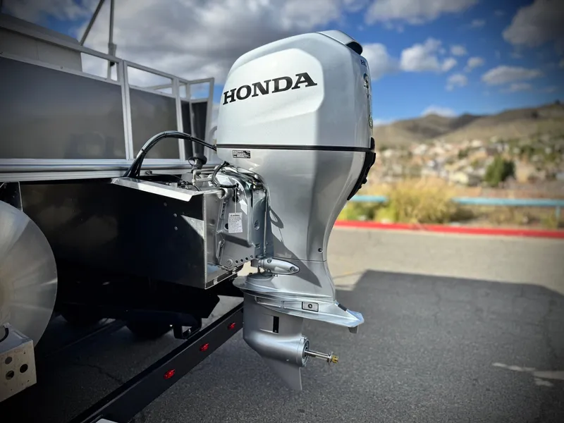 Slide: The Image of 2025 Berkshire 20 CRSE with Honda outboard motor, parked outdoors under a blue sky. - 7