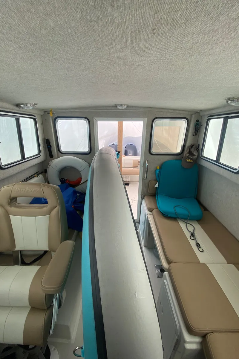 Slide: The Image of Interior of a 2018 Parker 2530 Extended Cabin boat with seating and windows. - 13
