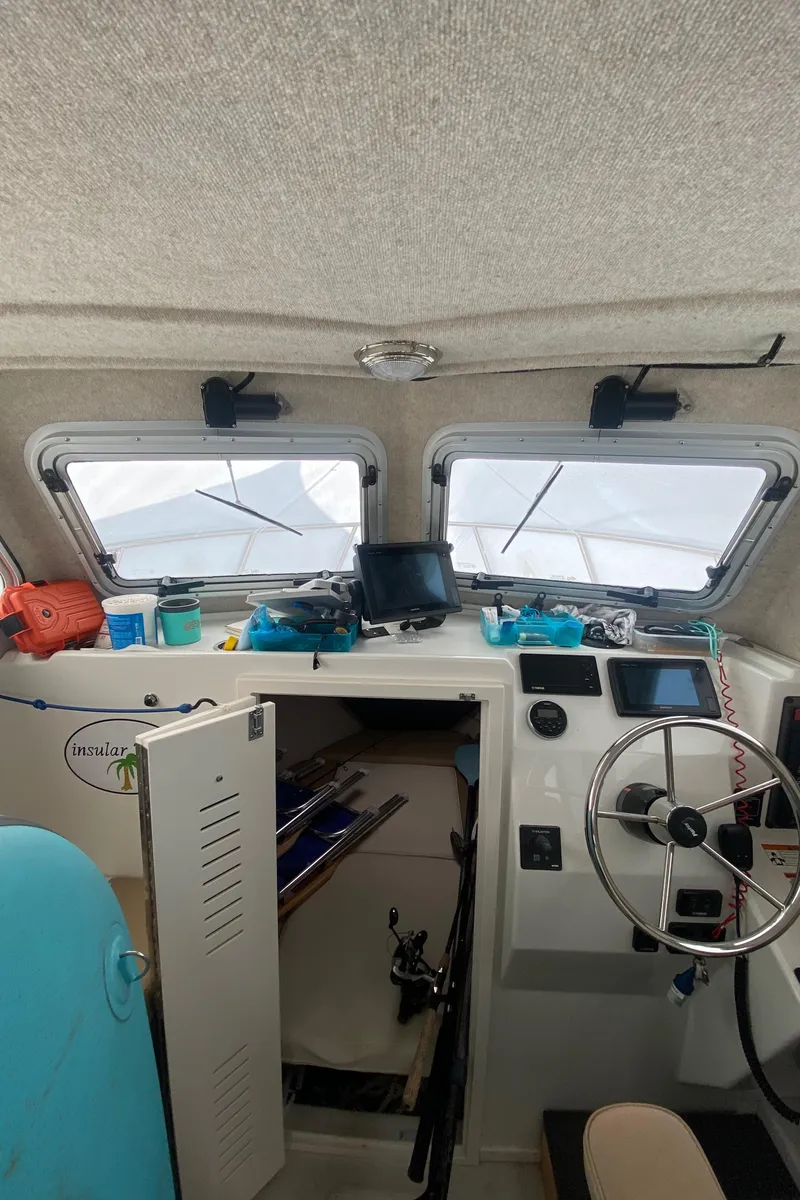 Slide: The Image of Interior of a 2018 Parker 2530 Extended Cabin boat with steering wheel and navigation equipment. - 17