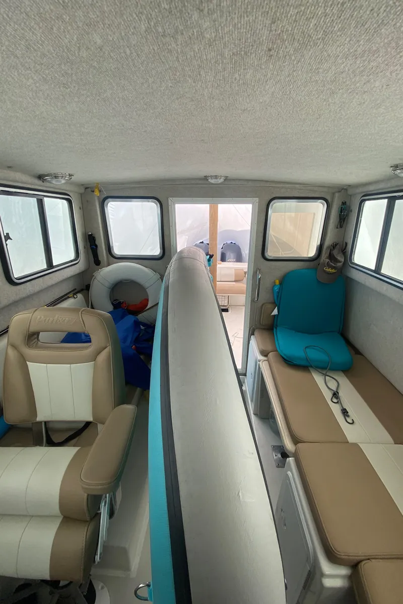 Slide: The Image of Interior of a 2018 Parker 2530 Extended Cabin boat with seating and windows. - 18