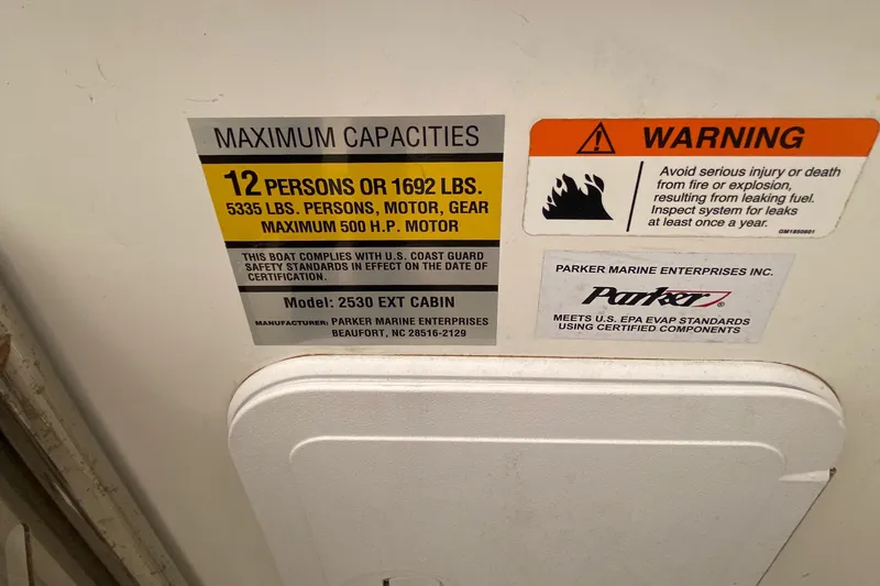 Slide: The Image of Capacity and warning labels on a 2018 Parker 2530 Extended Cabin boat. - 19